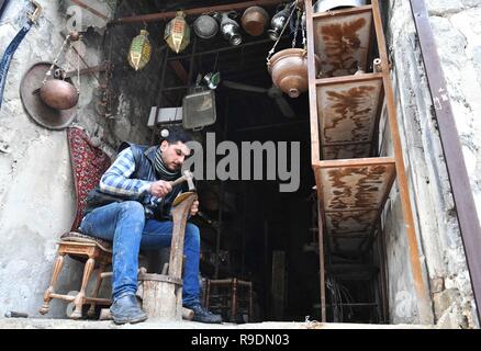 (181222) -- Alep (Syrie), le 22 décembre 2018 (Xinhua) -- une République chaudronnier travaille dans son atelier à l'Al-Nahhasin Souk, un marché spécialisé dans la vente de produits en cuivre à la main, à Alep, en Syrie du nord, le 19 décembre, 2018. En Syrie du nord de la ville d'Alep, la détermination des habitants à reconstruire leur vie et de la ville est plus forte que la destruction massive qui s'est abattu sur eux. Deux ans après sa libération, les gens ont déjà retroussé leurs manches et ont commencé la destruction de fixation dans l'ancien marché de la ville fortifiée, pas découragé par la dévastation. (Xinhua/Ammar S Banque D'Images