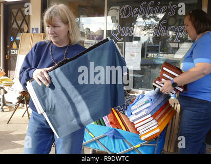 Paradis, USA. Dec 19, 2018. Propriétaire de l'entreprise Debbie Alberg (Debbie's Quilt Shop) supprime les balles de tissu endommagé sa boutique. Un arbre était tombé à travers le toit lors de l'incendie, plus tard la pluie des marchandises. (Dpa 'traverse, cendres et de l'espoir - Paradise n'abandonne pas Feuerinferno' après du 23.12.2018) Crédit : Barbara Munker/dpa/Alamy Live News Banque D'Images