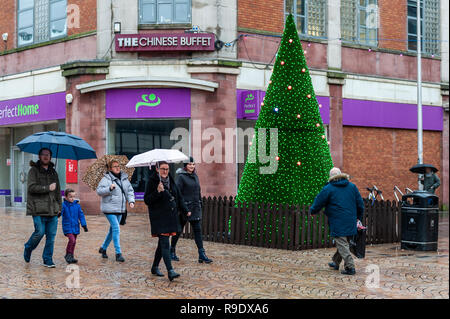 Blackpool, Royaume-Uni. Dec 23, 2018. Col Shoppers un arbre de Noël à Blackpool tout en faisant leurs achats de Noël. Les températures vont chuter à seulement 1° C durant la nuit, mais demain, c'est configuré pour être sec et lumineux avec éclaircies et des températures maximales de 8° C. Crédit : Andy Gibson/Alamy Live News. Banque D'Images