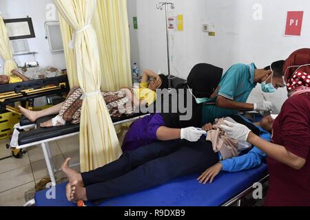 Banten, Indonésie. Dec 23, 2018. Les blessés reçoivent un traitement dans Cinangka clinique après un tsunami a frappé dans le détroit de Sunda Pandeglang, province de Banten, en Indonésie, le 23 décembre 2018. Le total des victimes d'un tsunami provoqué par l'éruption du volcan Krakatau Enfant a augmenté à 168 personnes dans les régions côtières du détroit de la sonde de l'ouest de l'Indonésie, la fonctionnaire de l'agence dit ici le dimanche. La catastrophe a tué au moins 168 personnes, en ont blessé au moins 745, et s'est effondré un total de 430 maisons et neuf hôtels, et a causé des dommages à des dizaines de navires. (Xinhua/Wahyu Wening) Credit : Xinhua/Ala Banque D'Images