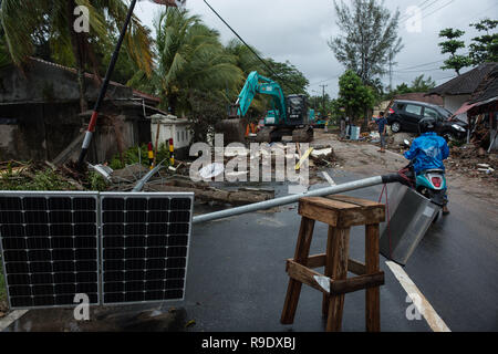 Pandeglang, Indonésie. Dec 23, 2018. Un excavateur nettoie route de débris après un tsunami a frappé dans le détroit de Sunda Pandeglang, province de Banten, en Indonésie, le 23 décembre 2018. Le total des victimes d'un tsunami provoqué par l'éruption du volcan Krakatau Enfant a augmenté à 168 personnes dans les régions côtières du détroit de la sonde de l'ouest de l'Indonésie, la fonctionnaire de l'agence dit ici le dimanche. La catastrophe a tué au moins 168 personnes, en ont blessé au moins 745, et s'est effondré un total de 430 maisons et neuf hôtels, et a causé des dommages à des dizaines de navires. Sanovri Crédit : Veri/Xinhua/Alamy Live News Banque D'Images