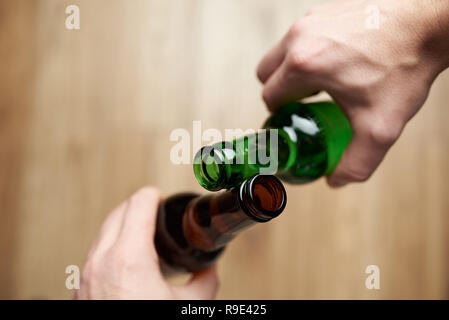 Bouteille de bière avec des amis d'encouragement fermer en haut Vue d'en haut. Thème célébrer Banque D'Images