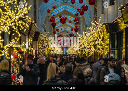 Un panier-Burlington Arcade à Mayfair, Londres au moment de Noël, en tant que consommateurs ne font de shopping de dernière minute Banque D'Images