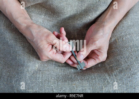 Les mains d'une vieille femme possèdent la clé. Close-up. Banque D'Images