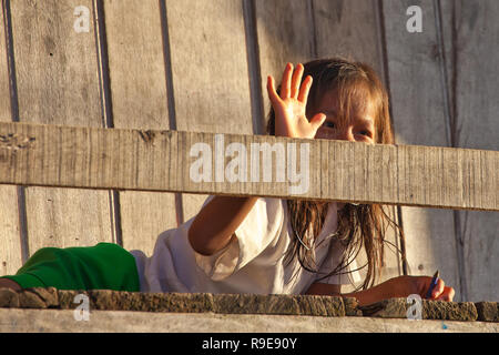 Une petite fille de sourire le porche de sa hutte au Belen au Pérou Banque D'Images