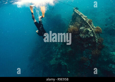 Freediver et barrière de corail avec des poissons près de wreckship Banque D'Images