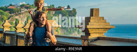 Père et fils les voyageurs à Pura Luhur Uluwatu temple, Bali, Indonésie. Un paysage extraordinaire - falaise avec ciel bleu et la mer. Bannière concept de voyager avec des enfants, format long Banque D'Images