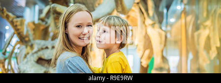 Maman et son fils regardant squelette de dinosaure en bannière musée, format long Banque D'Images