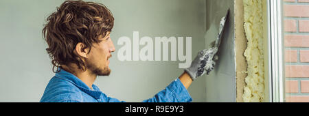 Master est l'application de mastic sur un mur et des bavures par couteau à mastic dans une chambre de la rénovation de maison dans journée BANNER, format long Banque D'Images
