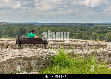 Belgrade, Serbie- 16 Août 2014 : l'homme assis sur le banc dans la forteresse de Belgrade dans le parc de Kalemegdan. Fragment de murs de défense. Forêt dans la background Banque D'Images