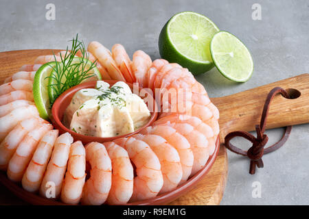 Gros plan sur couronne de crevettes avec du fromage frais et de la chaux sur planche de bois sur un fond clair Banque D'Images