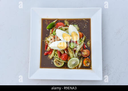 Salade de concombre épicé thaï / oeuf tranche de concombre mélanger les ingrédients la cuisson garnissez de tomates aux herbes et citron vert oeuf dur sur plaque blanche - traditional thai style Banque D'Images