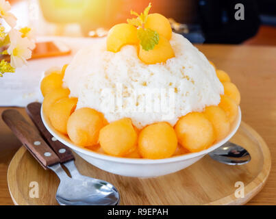 Corée style Bingsu dessert / bingsu bingsoo cantaloup bac sur table en bois - desserts sucrés fruits melon cantaloup rasée coréen sur la glace topping avec mil Banque D'Images