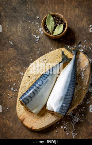 Le poisson frais. La cuisson du poisson ingrédients pour la marinade. Le maquereau avec sel et épices sur une table en bois. Copier l'espace. Banque D'Images
