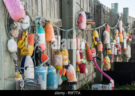 Bateaux de pêche et des bouées et des jouets suspendus à des cordes sur une clôture en bois. Banque D'Images