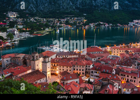 Maisons aux toits rouges et des bateaux sur la côte Adriatique, dans la baie de Kotor, Monténégro au crépuscule Banque D'Images