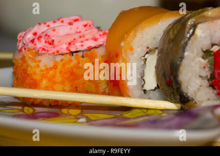 Rouleaux de sushi avec du saumon, l'anguille, le fromage à la crème Philadelphia, caviar tobica et bâtonnets sur la plaque Banque D'Images