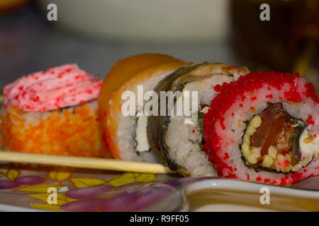 Rouleaux de sushi avec du saumon, l'anguille, le fromage à la crème Philadelphia, caviar tobica et bâtonnets sur la plaque Banque D'Images