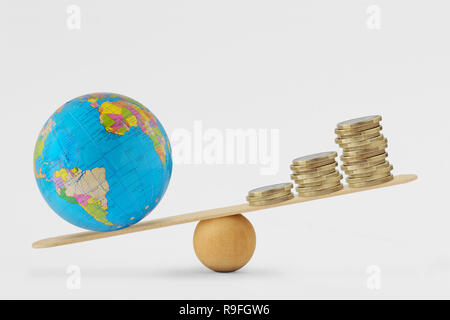 Globe terrestre et de l'échelle d'équilibre de la pile de pièces - concept de santé planétaire la priorité sur la croissance économique Banque D'Images