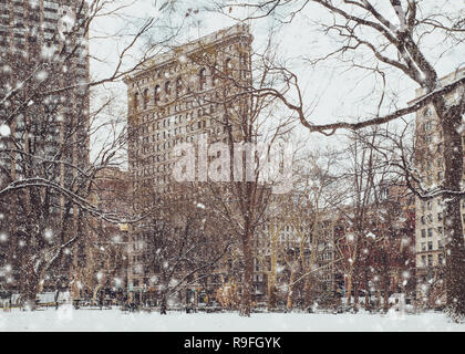 Voir l'historique de Flatiron building de Madison Square Park de New York Midtown Manhattan, avec des flocons de neige tombant pendant la tempête de neige Banque D'Images