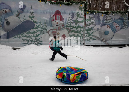 Enfants glissant sur une pente dans la tubulure du parc Sokolniki de Moscou Banque D'Images