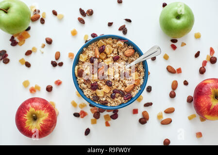 Réduire les callories. Vue de dessus du petit-déjeuner sain et utile, de l'avoine dans un bol et les fruits isolé sur fond blanc. Une collation ou un petit-déjeuner le matin. Cuillère en métal dans du muesli Banque D'Images