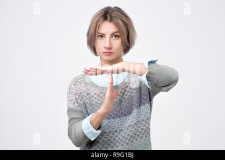 Portrait of attractive young woman showing time out sign Banque D'Images