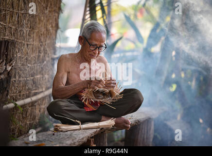 La vie Asie vieux grand-père oncle travaillant dans accueil / Asie vieil homme sérieux âgés vivant dans la campagne de vie des populations rurales en Thaïlande / weave Banque D'Images