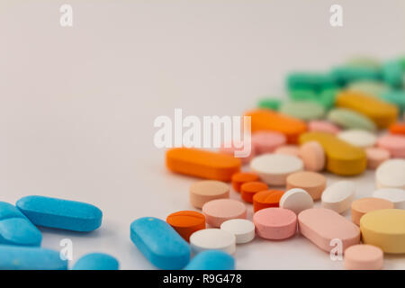 La drogue sous forme de médicaments. Des capsules et des comprimés de diverses couleurs et formes à usage humain. Produits pharmaceutiques sur fond blanc. Banque D'Images