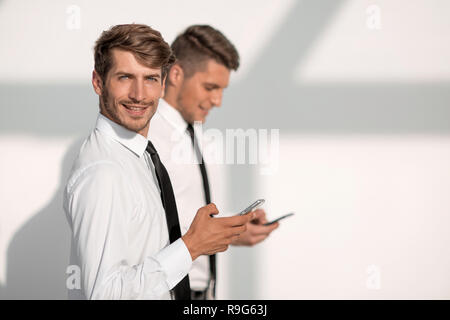 Businessmans holding mobile phone Banque D'Images