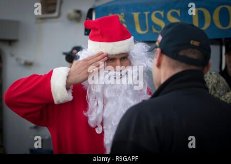 Rota, Espagne. Dec 22, 2018. Marin de la Marine américaine 1re classe Robert Camphouse, habillé en père Noël, salue avant de descendre la classe Arleigh Burke destroyer lance-missiles USS Donald Cook que le navire arrive à la base navale de Rota, 22 décembre 2018 à Rota, en Espagne. Credit : Planetpix/Alamy Live News Banque D'Images