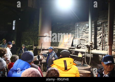 Wurzbach, Allemagne. Le 24 décembre, 2018. Les visiteurs suivent les explications d'employé Dirk Günther (M) à l'exposition moulage dans la fonderie Heinrichshütte monument technique. Show casting events ont lieu régulièrement dans les salles de l'ancienne, où les visiteurs peuvent revivre l'historique de la production de fonte. Credit : Bodo Schackow Zentralbild-/dpa/ZB/dpa/Alamy Live News Banque D'Images