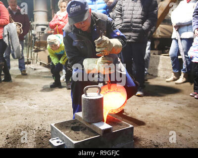 Wurzbach, Allemagne. Le 24 décembre, 2018. Dirk Günther remplit d'aluminium à chaud dans un moule au cours d'une inspection au moulage Fonderie Heinrichshütte monument technique. Show casting events ont lieu régulièrement dans les salles de l'ancienne, où les visiteurs peuvent revivre l'historique de la production de fonte. Credit : Bodo Schackow Zentralbild-/dpa/ZB/dpa/Alamy Live News Banque D'Images