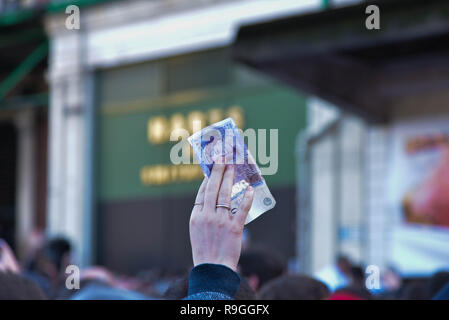 Londres, Royaume-Uni. 24 décembre 2018. Une femme nous tend un billet de 20 € à Hart de Smithfield tenir leur réveillon de Noël traditionnelle vente aux enchères de la viande. Credit : claire doherty/Alamy Live News Banque D'Images