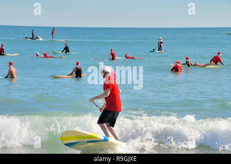 Cocoa Beach, Floride, USA. 24 décembre 2018 au cours des neuf dernières années, avant que le père Noël offre des jouets et des cadeaux, il a été de se détacher d'attraper quelques vagues dans Cocoa Beach la veille de Noël matin. L'événement de Santa Surf est une tradition annuelle de Cocoa Beach qui rassemble des centaines de surfeurs habillés en Père Noël à l'une des plus célèbres plages du monde. Crédit photo : Julian Poireau/Alamy Live News Banque D'Images