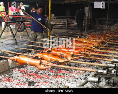 Quezon City, Philippines. 15 mars, 2012. Un lechonero les graisses de porc rôti. Le Lechon sera ensuite vendu comme un aliment traditionnel pour la fête de Noël. Credit : Josefiel Rivera SOPA/Images/ZUMA/Alamy Fil Live News Banque D'Images