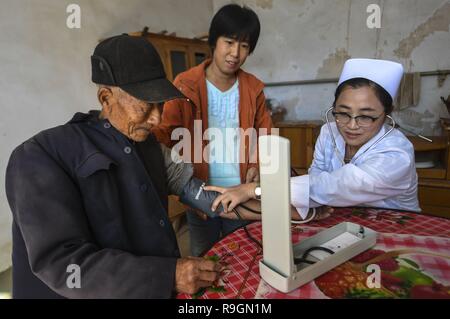 (181225) -- BEIJING, 25 décembre 2018 (Xinhua) -- une infirmière vérifie la pression artérielle pour un résident au village de Nanma Gucheng County au Nord de la province de Hebei, Chine Le 29 octobre 2017. Le gouvernement chinois a dépensé 5,95 milliards de yuans (environ 862 milliards de dollars américains) sur les services médicaux de 2013 à 2017, avec une augmentation annuelle moyenne de 11,7  %, selon un rapport soumis au Congrès National du Peuple, le parlement chinois en Chine. Les dépenses budgétaires de la Chine sur les services médicaux en 2017 était de 1,4 billions de yuans, une augmentation de 55,5 pour cent à partir de 2013, soit 7,1 pour cent de la dépense fiscale Banque D'Images