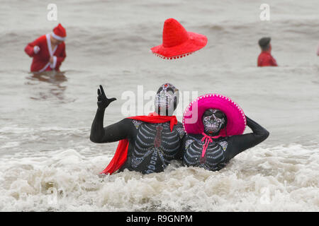 Charmouth, Dorset, UK. Dec 25, 2018. Le jour de Noël des nageurs portant robe de braver l'eau froide pour se rafraîchir dans la mer à Charmouth dans Dorset pour recueillir des fonds pour la RNLI. Crédit photo : Graham Hunt/Alamy Live News Banque D'Images