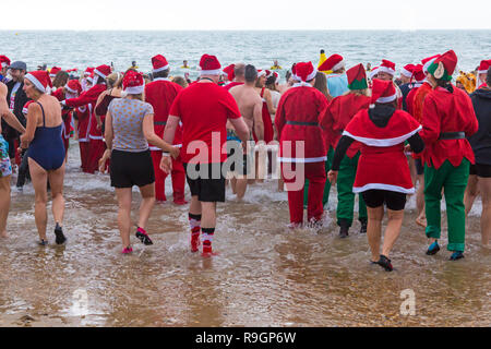 Boscombe, Bournemouth, Dorset, Royaume-Uni. Jour de Noël 25 décembre 2018. Des bénévoles courageux se plongent dans la mer froide et agitée pour nager, pour l'association caritative annuelle White Christmas DIP, vêtue de costumes habillés de fantaisie et amassant de l'argent pour Macmillan Caring local à Christchurch, une unité de soins palliatifs spécialisée pour les patients de la communauté locale. Des centaines prennent part à l'événement qui est devenu une tradition populaire pour beaucoup avant leur déjeuner de Noël. Crédit : Carolyn Jenkins/Alay Live News Banque D'Images