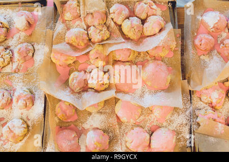 Petits gâteaux de coco en formes silicone close-up. Moules de cuisson rempli par les matières de la pâte sucrée en fleur, étoile ou cercle. Pâtisseries sablés délicieux sur bois Banque D'Images