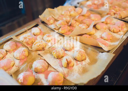 Petits gâteaux de coco en formes silicone close-up. Moules de cuisson rempli par les matières de la pâte sucrée en fleur, étoile ou cercle. Pâtisseries sablés délicieux sur bois Banque D'Images