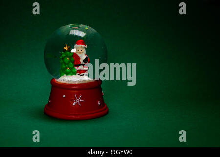 Santa en snow globe isolé sur fond vert, concept de décoration de Noël Banque D'Images