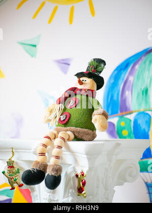 Fait main en tissu mignon comme jouet de Noël Bonhomme assis sur colonne, porter le chandail confortable, belle écharpe et chapeau Banque D'Images