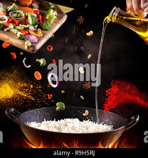 Biryani végétarien indien avec des légumes et épices en cuisine sur fond noir Banque D'Images