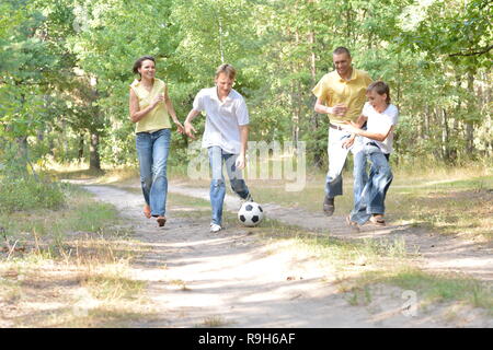 Happy Cute family playing soccer in park Banque D'Images