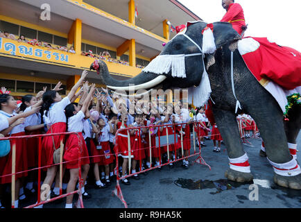Ayutthaya, Thaïlande. Le 24 décembre, 2018. Un éléphant vêtu d'un costume de Père Noël effectue pour les étudiants pendant les fêtes de Noël à l'école en Jirasart province d'Ayutthaya, au nord de Bangkok, en Thaïlande le 24 décembre 2018. Chaiwat Subprasom Crédit :/Pacific Press/Alamy Live News Banque D'Images