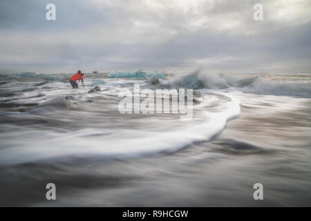 Photographe dans les vagues en Islande Plage Diamon Banque D'Images