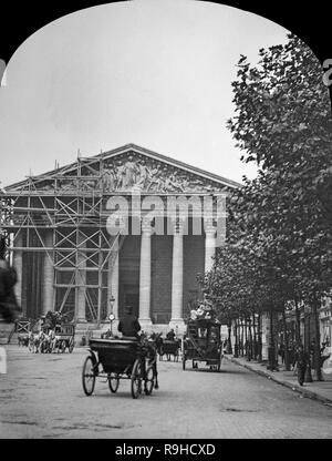 A la fin de 1970 Photographie noir et blanc montrant l'église de la Madeleine à Paris. C'est une église catholique romaine qui occupe une position dominante dans le 8ème arrondissement de Paris. L'église de la Madeleine a été conçu dans sa forme actuelle comme un temple à la gloire de l'armée de Napoléon. Au sud se trouve la Place de la Concorde, à l'est la Place Vendôme, et à l'ouest Saint-Augustin, Paris. C'est la construction a commencé en 1764, mais ne fut achevé qu'en 1842. Image montre calèches et des personnes. Montre également les échafaudages en place pour les travaux à effectuer. Banque D'Images