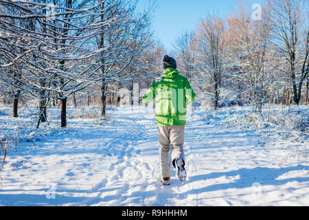 L'athlète course sprint homme forêt en hiver. La formation à l'extérieur en temps de neige froide. Vie saine et active Banque D'Images