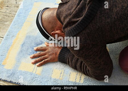 Homme musulman priant avec tapis sur le sol avec photo de stock de personnes Banque D'Images